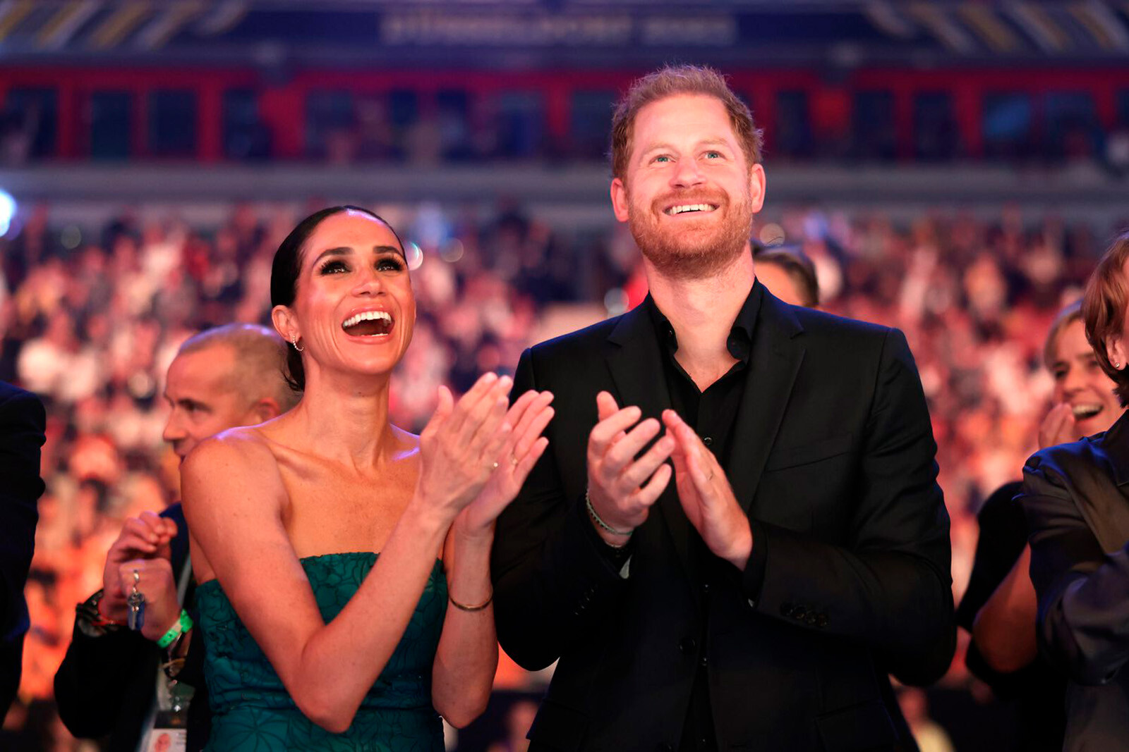 Меган Меган и принц Гарри радостно смотрят на сцену и аплодидируют