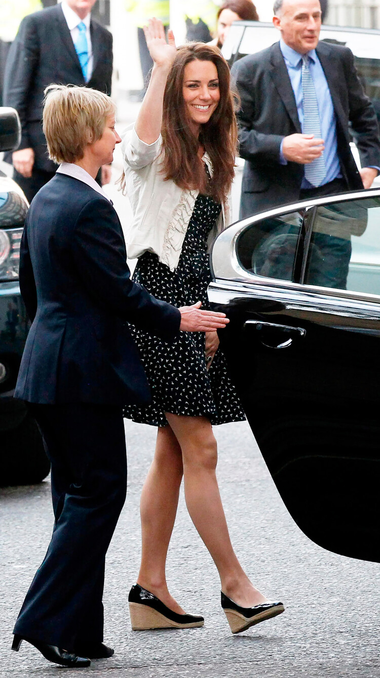 Кейт Миддлтон машет толпе покидая место репетиции свадебной церемонии с принцем Уильямом. До королевской свадьбы в Вестминстерском аббатстве оставалось менее 24 часов 28 апреля 2011 года в Лондоне, Англия