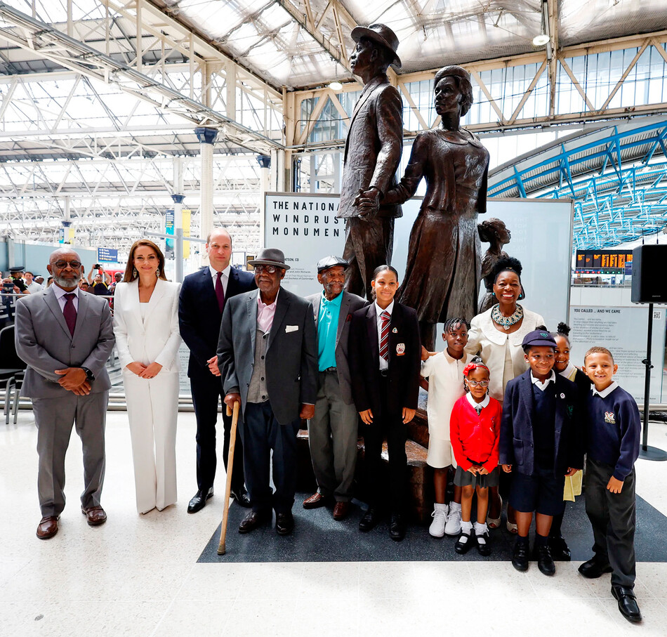 Принц Уильям и Кэтрин, герцогиня Кембриджская в сопровождении баронессы Флоэллы Бенджамин позируют для фотографии рядом с Национальным памятником Виндраш на вокзале Ватерлоо 22 июня 2022 года в Лондоне, Англия