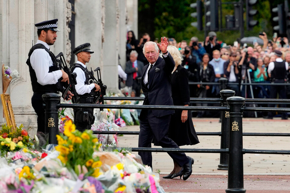 Король Карл III и Камилла, королева-консорт возвращаются в Букингемский дворец после осмотра цветов, возложенных в честь покойной королевы Елизаветы II возле Букингемского дворца 9 сентября 2022 года в Лондоне, Великобритания