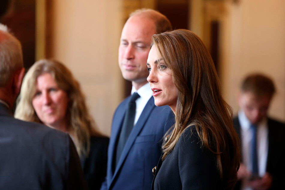 Принц Уильям, принц Уэльский и Кэтрин, принцесса Уэльская общаются с представителями волонтёров участвующих в организации похорон королевы Елизаветы II 22 сентября 2022 года в Виндзоре, Великобритания