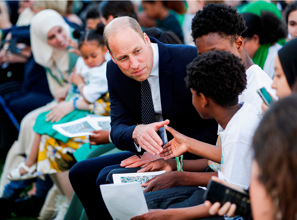 Принц Уильям общается с участником поминальной службы у подножия Гренфелл-Тауэр в Лондоне, 14 июня 2022 года