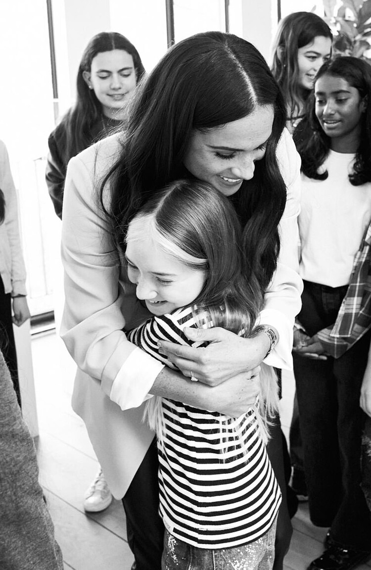 Меган Макрл искренне обнимает восторженную юную ученицу, 2022