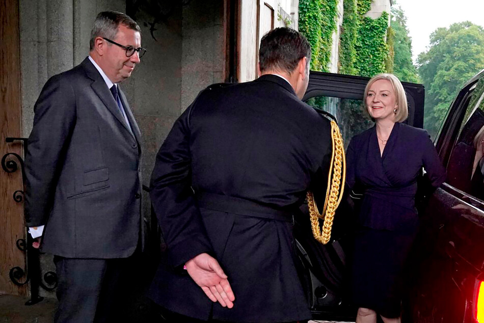 Новоизбранного лидера Консервативной партии Лиз Трасс встречают подполковник конюшни королевы Елизаветы II Том Уайт и её личный секретарь сэр Эдвард Янг, когда она прибывает в замок Балморал для аудиенции, на которую она будет приглашена стать премьер-министром и сформировать новое правительство 6 сентября 2022 года в Абердине, Шотландия
