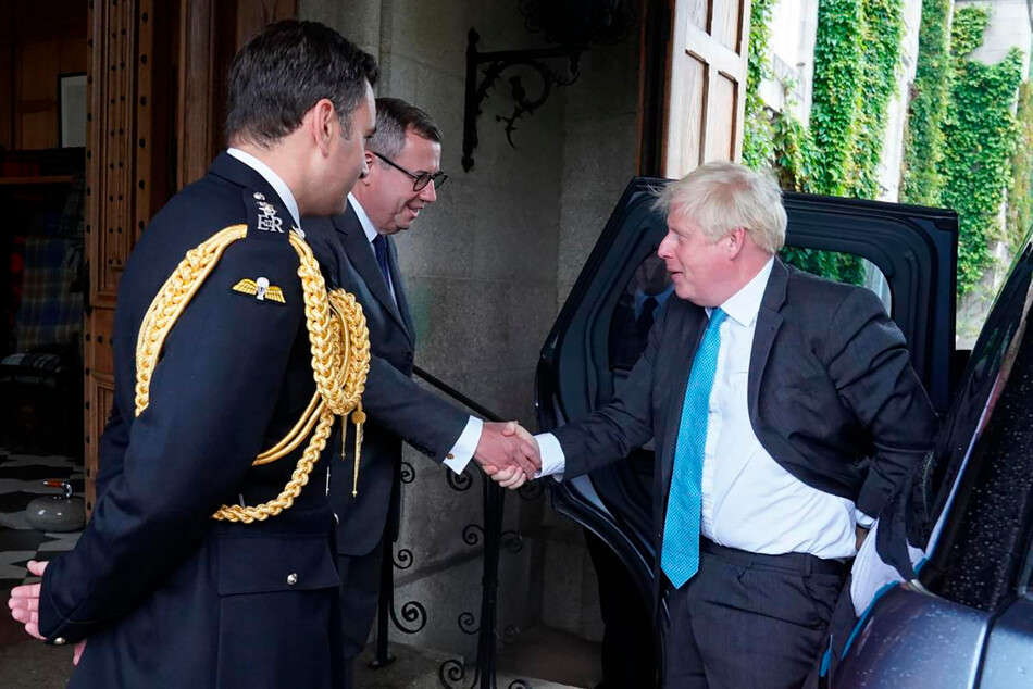 Уходящего премьер-министра Бориса Джонсона встречают подполковник конюшни королевы Елизаветы II Том Уайт и её личный секретарь сэр Эдвард Янг, когда он прибывает на аудиенцию, чтобы официально уйти с поста премьер-министра в замке Балморал 6 сентября